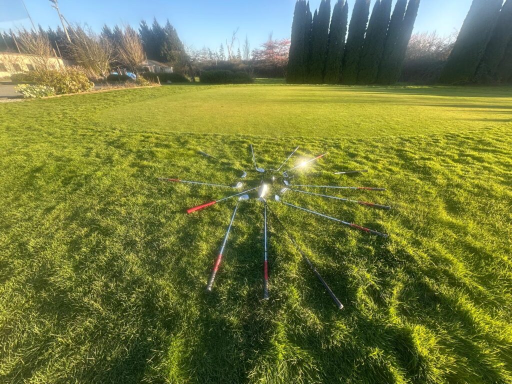 titleist golf irons arranged on grass at canadian driving range